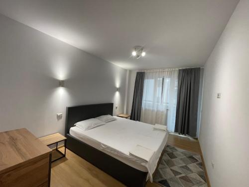 a small bedroom with a bed and a window at Cozy London Escape in Suceava