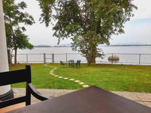 a table and chairs on the grass by the water at Oga Reach Yala in Lukasgoda