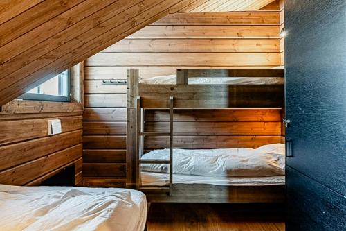 two bunk beds in a room with wooden walls at Mountain Lodge With Views Over Idre in Idre
