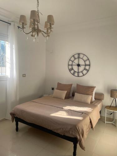 a bedroom with a large bed with a clock on the wall at Villa doullia in El Mây