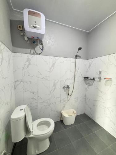 a bathroom with a toilet and a shower in it at Villa Andira Hidden Paseban in Pondok Cipaseban