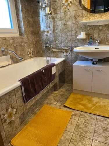 a bathroom with a tub and a sink at Ferienwohnung Hakuna Matata in Bad Aussee