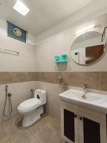 a bathroom with a toilet and a sink and a mirror at Montana Lodges Murree in Murree