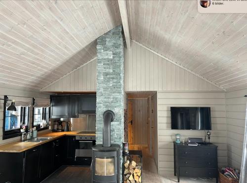 a kitchen with a wood stove in the middle at Cozy family cabin at Hovden in Bykle