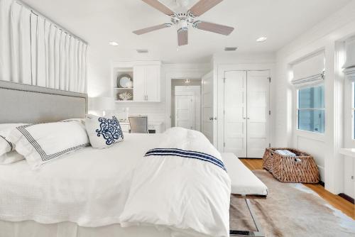 a white bedroom with a bed and a ceiling fan at On the Beach in Santa Rosa Beach