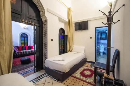 a bedroom with a bed and a living room at ROOM iN FES MEDINA in Fès