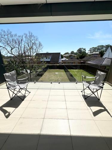two chairs sitting on top of a patio at Master room with Ensuite Near Train Station Airport in Revesby