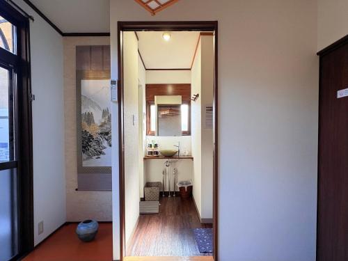 a hallway with a door leading to a bathroom at 夏様四条大宮 四条大宮駅5分 京都市中心部 一棟一組貸切 広い庭付き一戸建て in Kyoto