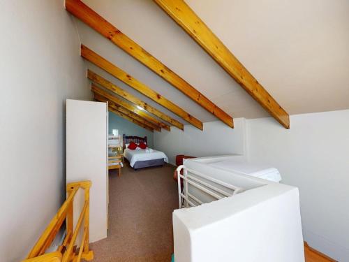 a attic room with a bed and a staircase at Bay view sea cottage in Victoria Bay