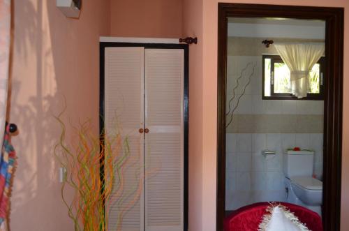 a bathroom with a toilet and a mirror at My Angel in La Digue