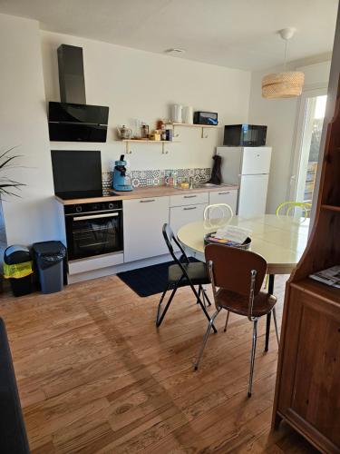 a kitchen with a table and a table and chairs at Maison familiale Pont Aven in Pont-Aven