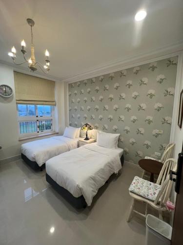 a bedroom with two beds and a wall with birds at 屋子旅店 in Puli