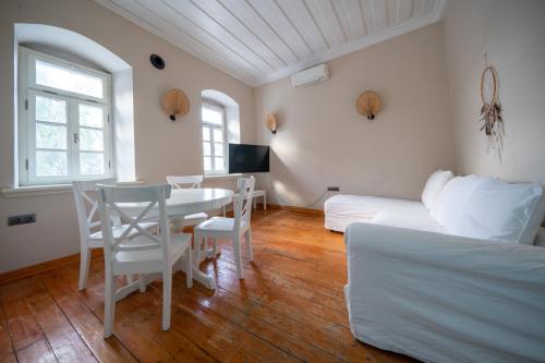 a living room with a table and a couch at MINIQ HOMES 103 - Stone House with Garden Cinema, Barbecue, Mini Golf in Foca