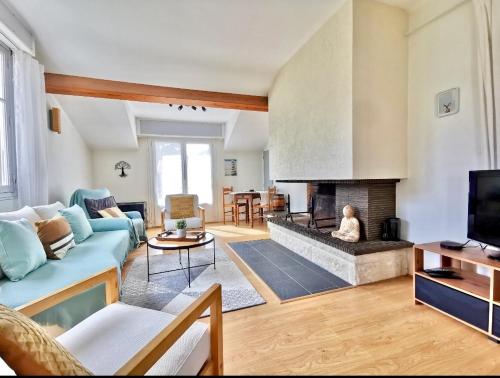 a living room with a couch and a fireplace at Charmant dupleix à La Baule, proche de la mer in La Baule