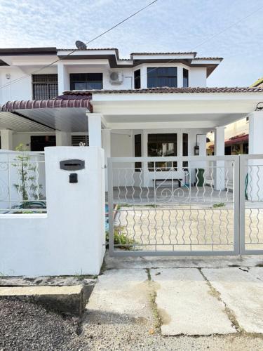 a white fence in front of a house at relaxing home in Bukit Mertajam in Bukit Mertajam