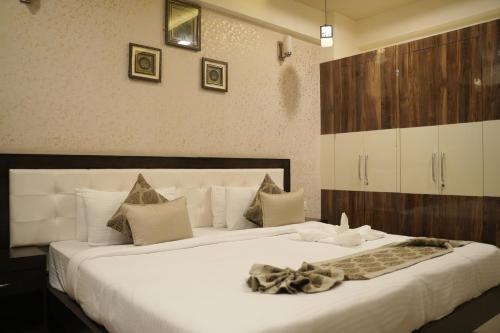 - une chambre avec un grand lit blanc et une couverture dans l'établissement Avasa Homestay, à Thūr