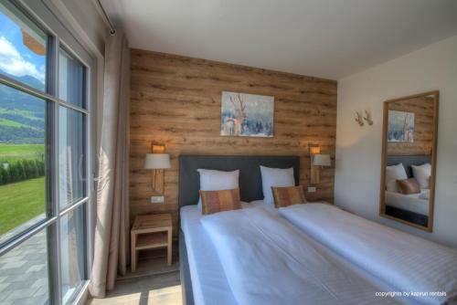 une chambre avec un grand lit et une grande fenêtre dans l'établissement Deer & Dear Luxury Chalet, à Piesendorf