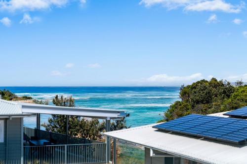 a view of the ocean from a house with solar panels at Stunning Ocean-View Home, Walk to Village & Beach in Sawtell