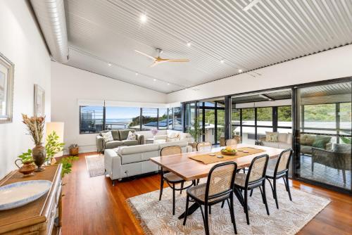 a living room with a table and chairs and a couch at Stunning Ocean-View Home, Walk to Village & Beach in Sawtell
