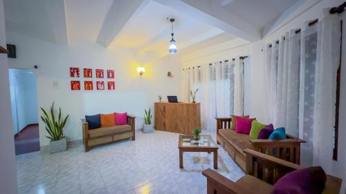 ein Wohnzimmer mit Sofa und Tisch in der Unterkunft Cottage Haven Villa in Galle