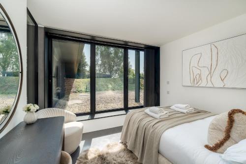 um quarto com uma cama, uma mesa e uma janela em Pass the Keys Bond-villain Style Home with Panoramic Views em Enborne