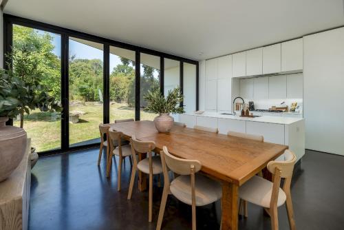 uma cozinha e sala de jantar com mesa e cadeiras de madeira em Pass the Keys Bond-villain Style Home with Panoramic Views em Enborne