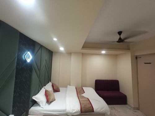 a bedroom with a bed and a purple chair at Hotel O KOLKATA SEVEN INN LLP in Salkhia