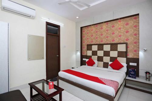 a bedroom with a large bed with red pillows at Hotel O Unique Stay Inn in Bādshāhnagar