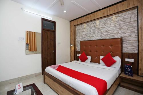 a bedroom with a large bed with red pillows at Hotel O Unique Stay Inn in Bādshāhnagar
