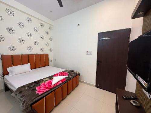 a bedroom with a bed with pink flowers on it at Hotel O Sri in Banāras Cantonment