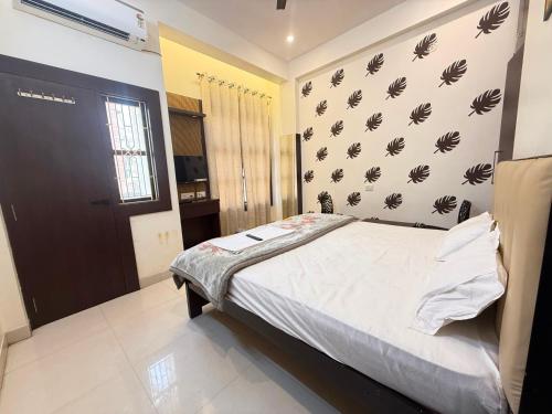a bedroom with a bed and a black and white wall at Hotel O Sri in Banāras Cantonment