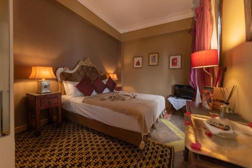 een slaapkamer met een bed en een tafel met een lamp bij Riad Ayadina & SPA in Marrakesh