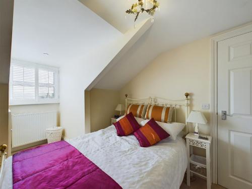 a bedroom with a bed with purple and white sheets at Sea Loft Penthouse - Whitby in Whitby