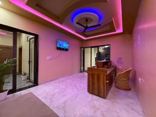 una habitación con paredes rosas y techo con luces moradas en Braham Niwas Resort, en Pushkar