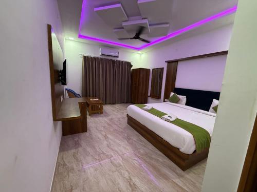 Un dormitorio con una cama grande con iluminación violeta. en Braham Niwas Resort, en Pushkar