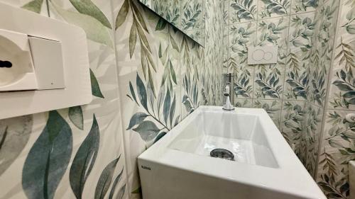een witte wastafel in een badkamer met planten aan de muur bij Cielo Sereno in Napels