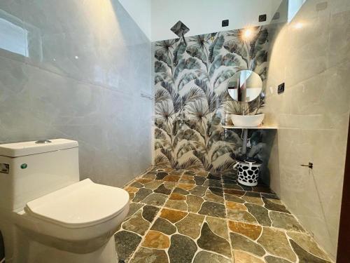 a bathroom with a toilet and a tile floor at Serene Pool Villa-Coffee Estate Stay,Mudigere in Mudigere