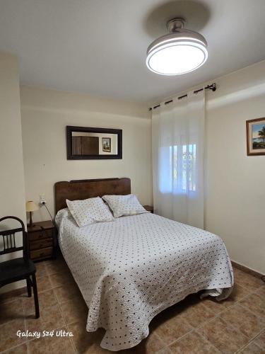a bedroom with a bed with a white comforter at Casa Rural Consuelo in Jumilla