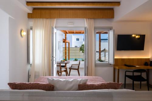 a bedroom with a bed and a balcony with a table at Safrani Suites in Santorini