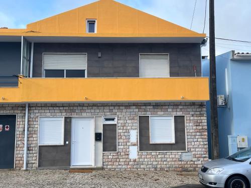 a brick house with a car parked in front of it at Sun House - Apartamento - Sintra in Belas