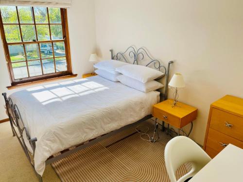 een slaapkamer met een bed, een bureau en een raam bij Hillside Retreat with Pool in Flagstaff Hill