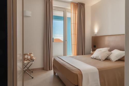 a bedroom with a bed with a view of the ocean at Vela Azzurra Holiday Home in Grottammare