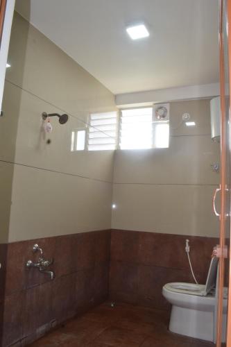 a bathroom with a toilet and a window at Sri Darshini Comfort 2kms from Hinkal Flyover in Mysore