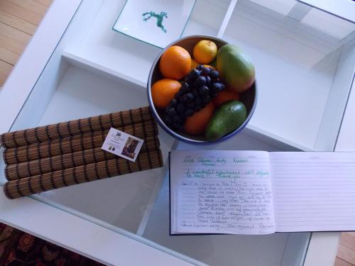 un cesto di frutta su un tavolo accanto a un libro di Violet Bank Apartment Morningside a Edimburgo