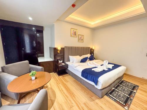 a hotel room with a bed and a table at The Fortunaa Avenue in Gwalior