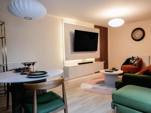 a living room with a table and a tv at Adeluxe Aura - Entire Ultra Luxury- Super King Bed with Free WiFi, Netflix and Amazon Prime in Burton upon Trent