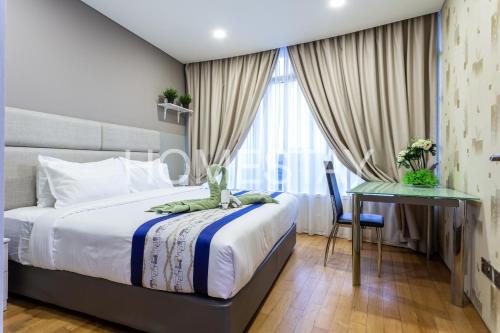 a bedroom with a bed and a desk and a window at Vortex Suites Klcc By Homestay in Kuala Lumpur