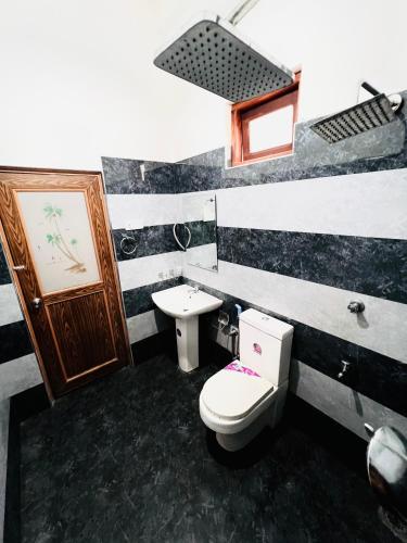 a bathroom with a toilet and a sink at Monkey Garden Hotel in Polonnaruwa