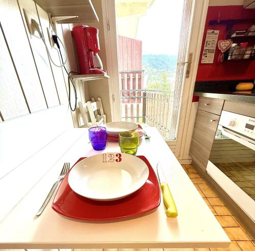 Ein rotes Tablett mit einem weißen Teller auf einer Küchentheke in der Unterkunft Studio chaleureux avec vue plein sud imprenable ! in Villard-de-Lans