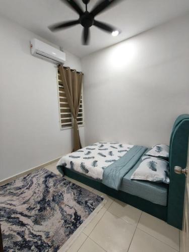 a bedroom with a bed and a ceiling fan at Eiman Homestay in Kuala Terengganu